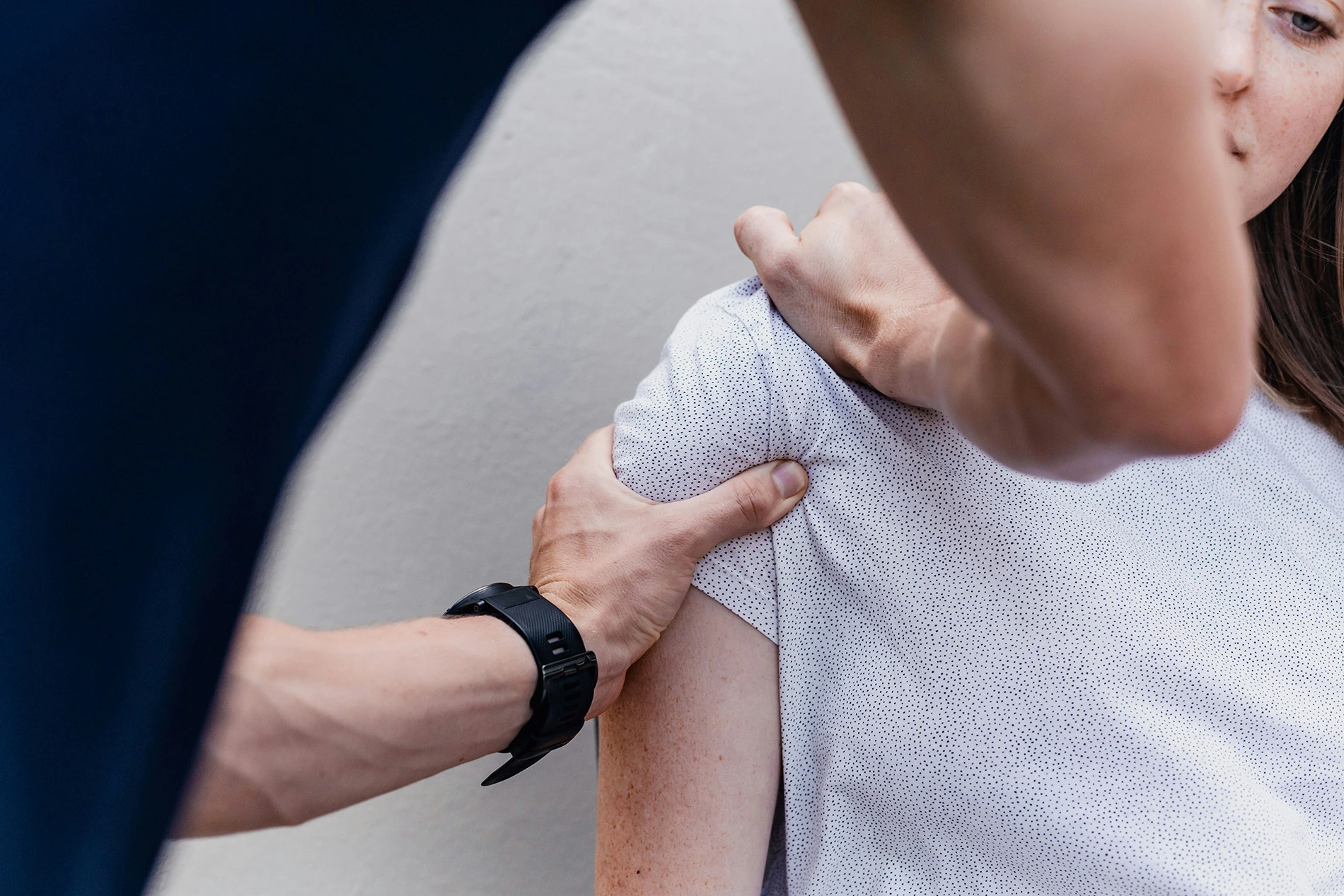 Physiotherapist massaging female clients shoulder to help her recover from an injury